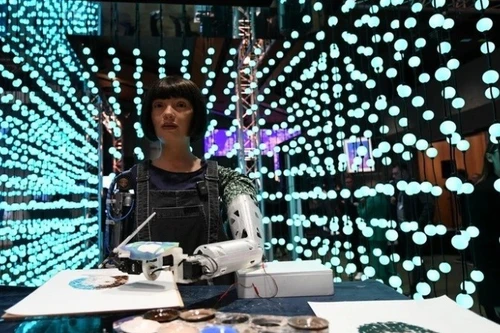 2024年5月30日人工智能人形机器人艺术家艾达（Ai-Da）在瑞士日内瓦举行的全球人工智能峰会上绘画。（图片来源：新华社/越通社）