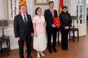 蒙古国驻越南大使冈巴塔尔·胡兰和蒙古国立艺术文化大学代表向导演黎贵阳授予“荣誉教授”称号。（明江 摄）