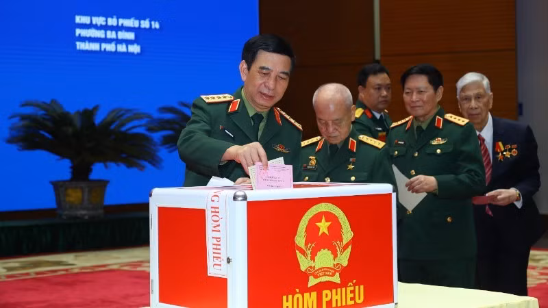 国防部部长潘文江大将和各位代表在河内市第14号投票区参加选举投票。