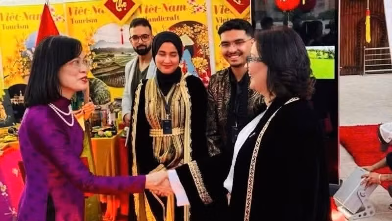 越南驻摩洛哥大使黎金龟欢迎国际友人前来参观越南展位。（图片来源：越南驻摩洛哥大使馆）