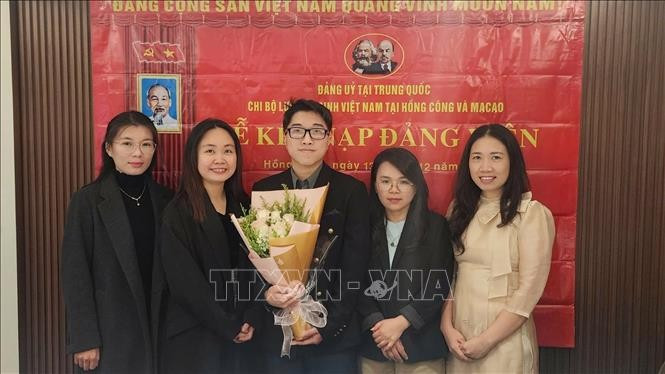 在新党员入党仪式上的香澳越南学生会党支部书记、澳门大学应用英语语言学研究生阮氏春惠（左二）。（图片来源：越通社）