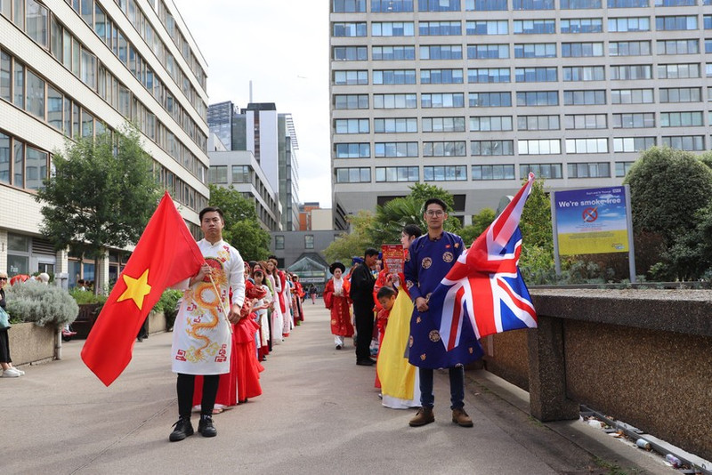 身着越南传统服饰的在英越南人参加游行活动。（图片来源：越通社）