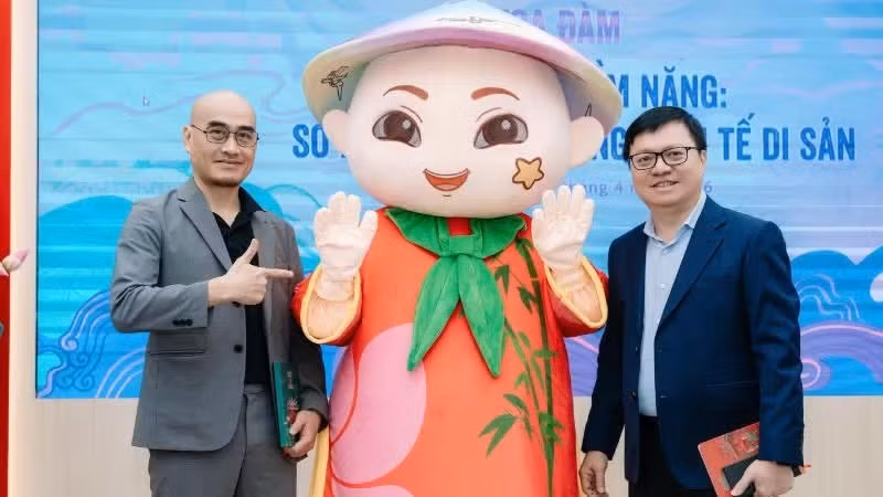 《人民报》总编辑黎国明与Ann集团董事长陶仲辉同竹哥吉祥物演示版本合影。