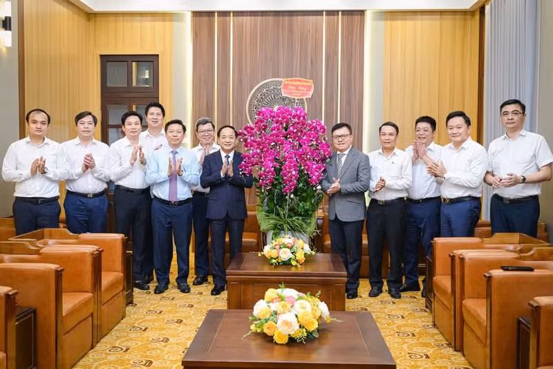 郑文决同志与工作代表团成员、《人民报》总编辑黎国明及该报社领导干部合影留念。