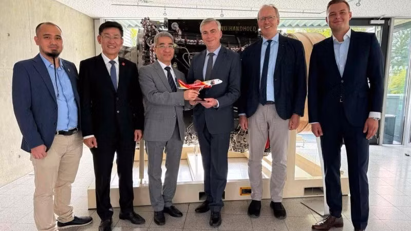 越南驻德国大使阮得成和越捷航空代表向德国联邦航空局领导赠送纪念品。（图片由越南驻德国大使馆提供）