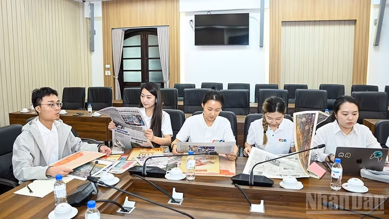 中国传媒大学代表团成员体验《人民报》的创新出版物。（图片来源：世代 摄）