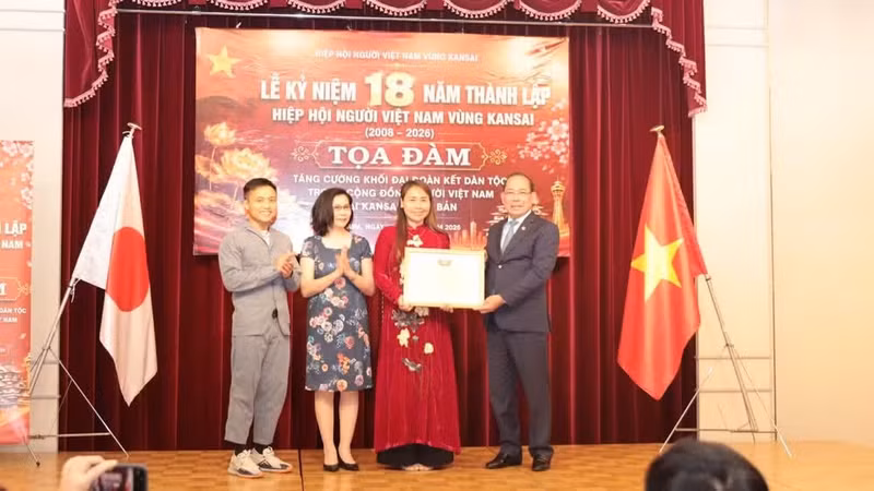 越南祖国阵线中央委员会副主席黄功水向关西越南人协会颁发越南祖国阵线中央委员会表彰状。（图片来源：忠信 摄）