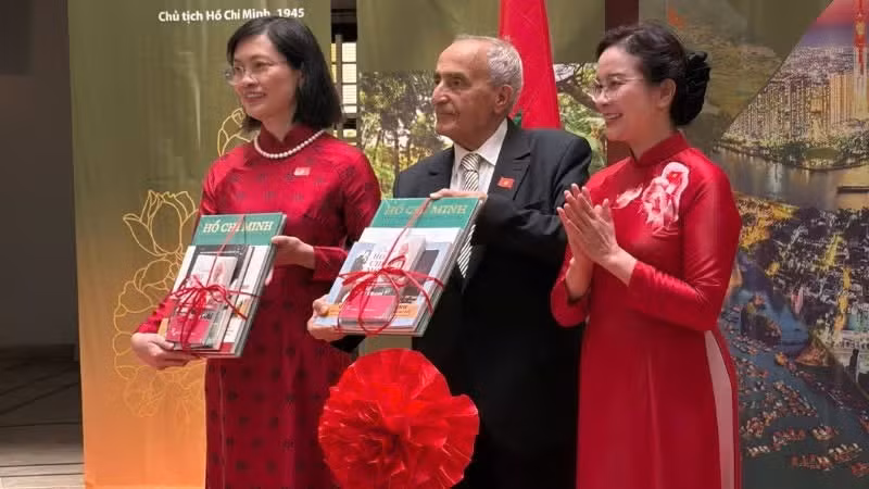 胡志明主席故居遗迹区主任黎氏凤向越南驻摩洛哥王国特命全权大使黎金龟和摩洛哥前抗战及前解放军成员事务高级专员Mustapha El Ktiri赠送有关胡志明主席及越南国家、人民的书籍和出版物。（图片来源：组委会提供）
