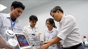 胡志明市工业大学电子技术学院教师引导学生学习和研究。（图片来源：越通社）