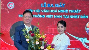 越南驻日本大使范光校向在日本的越南传统文化艺术协会会长杜庆欣女士送花祝贺。（图片来源：越通社）