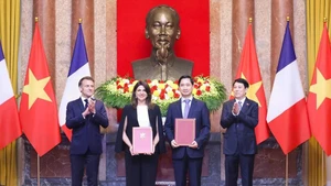 5月26日，越南国家主席梁强与法国总统埃马纽埃尔·马克龙共同见证双方合作文件的交换。（图片来源：VNVC）