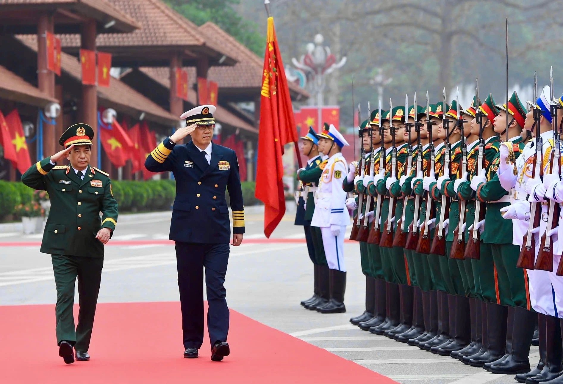 越南国防部部长潘文江大将同中国国防部部长董军上将检阅仪仗队。（图片来源：青年报）