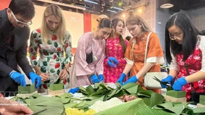 法国年轻人体验包越南粽子。（图片来源：越通社）