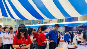 学生和大学生在邮电技术学院举行的“全国创新与数字化转型竞赛”运动启动仪式上体验虚拟现实技术。（图片来源：协德 摄）