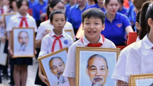 首都青少年在活动上与胡伯伯画像合影。