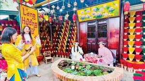 游客在顺化水春香村参观并体验活动。