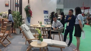 企业代表在胡志明市参观出口木制家具和室内装饰产品展览。