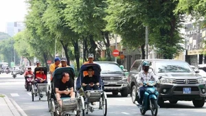 游客乘坐人力三轮车参观胡志明市中心。（图片来源：越通社）