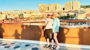 国际游客在安江省富国岛“接吻桥”打卡留影。