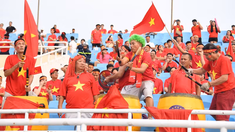 在体育场看台上，球迷挥舞着国旗、打着鼓为越南队助威。（陈海 摄）