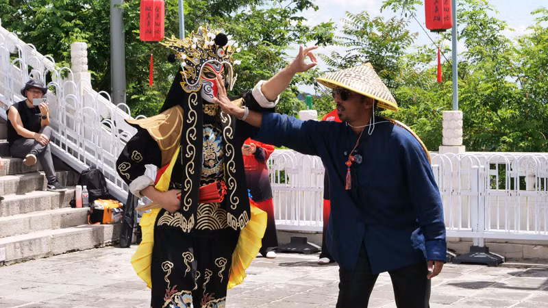 外国游客在慕田峪长城上观看变脸表演并与演员互动。