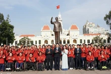 越南政府副总理梅文正与胡志明市各部委、机构代表以及越南残疾人体育代表团在胡志明主席纪念公园合影。（图片来源：越通社）