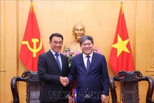 胡志明国家政治学院常务副院长阮维北副教授、博士会见来访的老挝人民革命党中央对外部代理部长本莱·班达努冯。（图片来源：越通社）