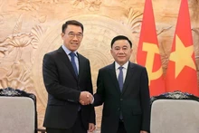 越共中央政治局委员、中央书记处常务书记陈锦秀（右）与老挝人民革命党中央对外部代理部长本莱·班达努冯。（图片来源：越通社）