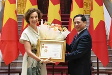 越南政府副总理兼外交部长裴青山向联合国教科文组织总干事奥德蕾·阿祖莱授予“致力于越南外交事业”纪念章。(图片来源:越通社)