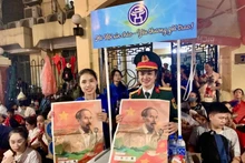 执勤人员和志愿者们高兴地领取《人民报》纪念9·2国庆特别副刊。