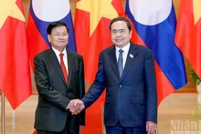 越南国会主席陈青敏与老挝人民革命党中央总书记、国家主席通伦·西苏里亲切握手。