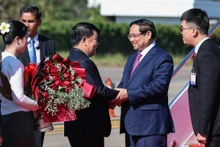 越南政府总理范明正抵达万象。（图片来源：VGP）