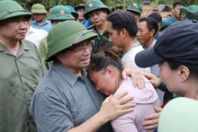 范明正总理对洪水灾区民众失去亲人的悲痛感同身受。（图片来源：越通社）