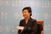 中国人民大学重阳金融研究院研究员刘英(右)接受越通社记者的采访。图自越通社