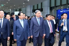 苏林总书记和范明正总理参观越南创新展。