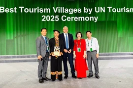 宣光省文化体育与旅游厅领导和倮倮寨旅游文化村村民接收“2025年世界最佳旅游乡村”称号。