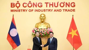 越南工贸部部长阮鸿延和老挝工贸部部长玛莱通·贡马西。（图片来源：moit.gov.vn）