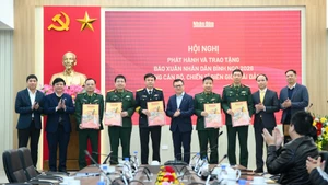 越共中央委员、《人民报》社总编辑、中央宣教与民运部副部长、越南新闻工作者协会主席黎国明和各单位领导向边境和海洋岛屿地区的干部、战士赠送2026丙午年春节特刊。