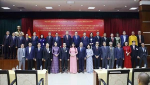 苏林总书记，越南驻老挝大使馆工作人员，旅居老挝越南人代表，和各位代表合影。（图片来源：越通社）