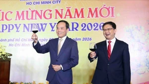 越共中央政治局委员、胡志明市市委书记陈流光（左）与出席活动的来宾举杯共庆新年。（图片来源：越通社）