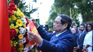 越南政府总理范明正在里约热内卢胡志明主席纪念牌前敬献花圈。（图片来源：越通社）