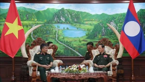越南国防部副部长阮文贤中将礼节性拜会老挝国防部长坎良·奥萨宋。（图片来源：越通社）