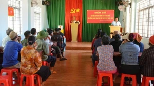 嘉莱省边境乡的干部向民众介绍选举相关信息。（图片来源：越通社）