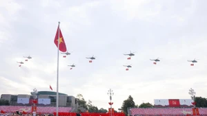 人民空军直升机编队悬挂党旗与国旗飞越河内上空。