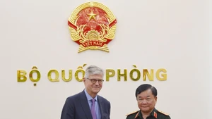 黄春战上将向联合国副秘书长让-皮埃尔·拉克鲁瓦赠送纪念品。（图片来源：qdnd.vn）