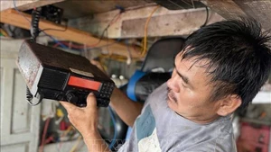 富安坊渔民出海前检查航程监控设备。（图片来源：越通社）