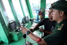 岘港市边防部队指挥部山茶边防站的干部、战士对渔民的渔船通信联络设备进行检查。（图片来源：越通社）