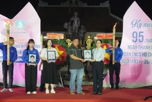 向越南英雄母亲及烈士家属赠送修复后的遗像。（图片来源：越通社）