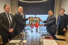 胡志明国家政治学院院长、中央理论委员会主席阮春胜向越英友好网络主席、前英国驻越大使马克·肯特送礼。(图片来源:越通社)