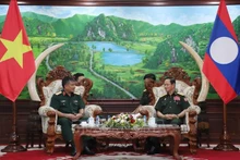 越南国防部副部长阮文贤中将礼节性拜会老挝国防部长坎良·奥萨宋。（图片来源：越通社）